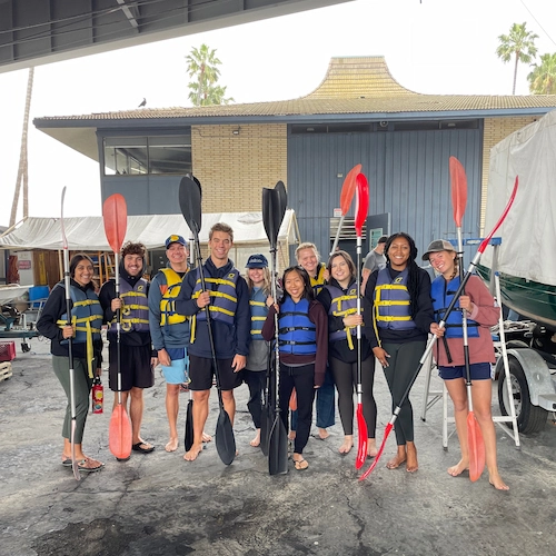 students posing for a group photo before kayaking