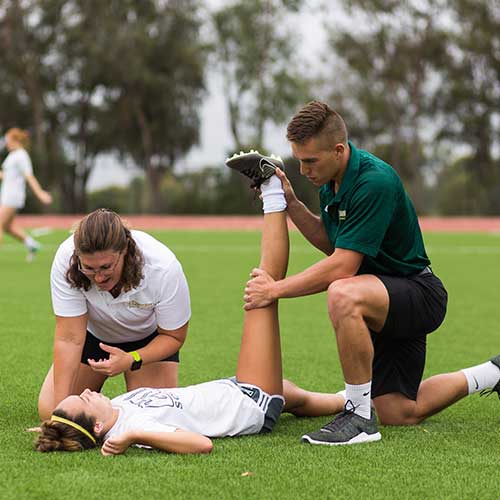 Athletic training student stretching an athlete.