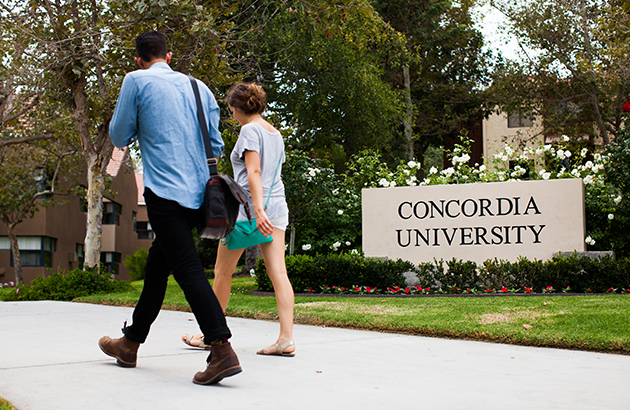 two students walking past a Concordia University sign