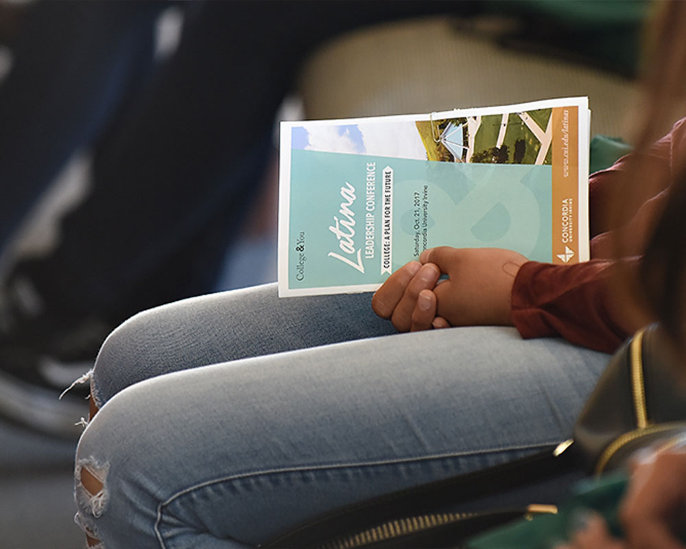 Girl sitting down with conference pamphlet