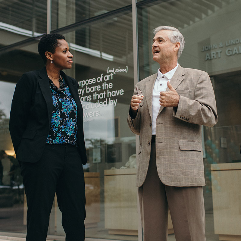 Professor speaking with a student on campus