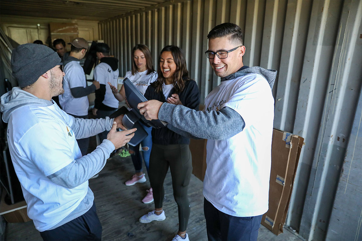 Volunteers passing a monitor. Photo credit: Alexander Kitano