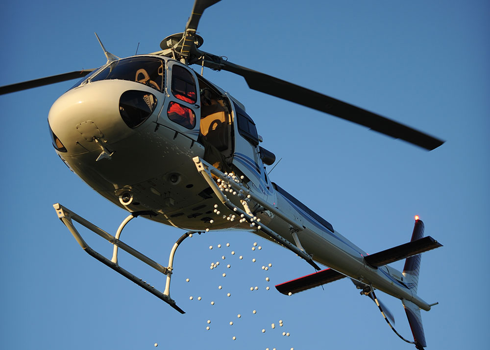A helocopter dropping golf balls