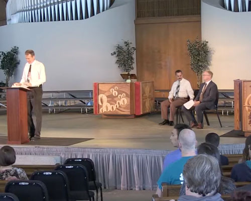 Theology professor speaking at a podium