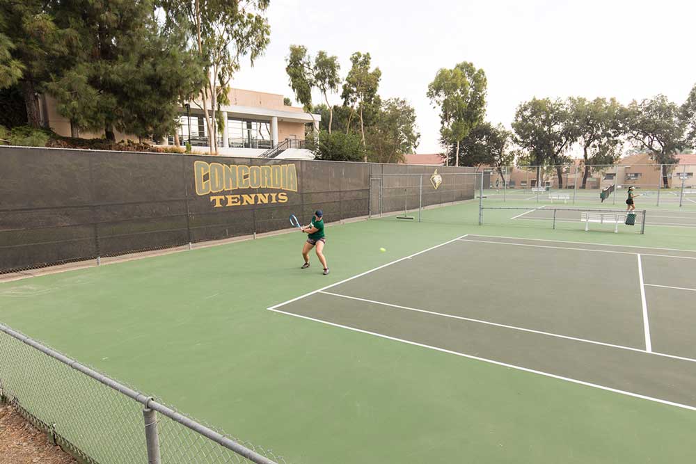Tennis players practice on the courts at Concordia.