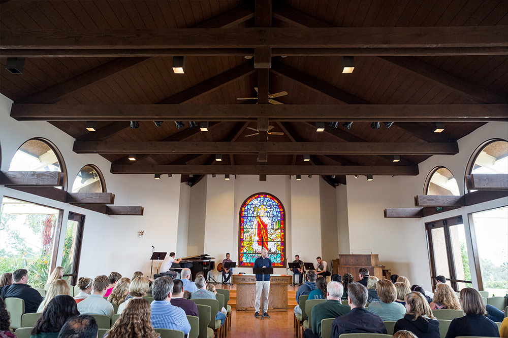 A speaker welcomes the audience at Good Shepherd Chapel.