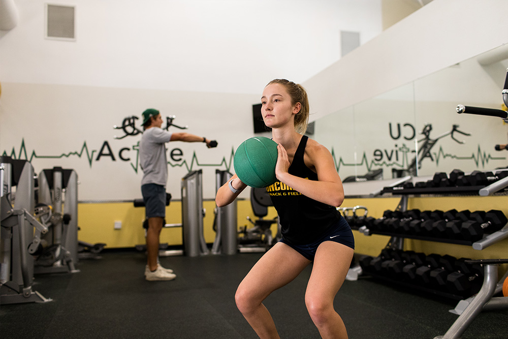 Students engage in weight-training in the CU Active Fitness Center.