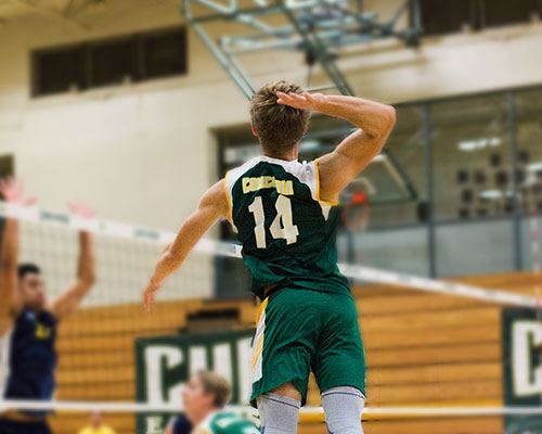 Volleyball player hitting ball