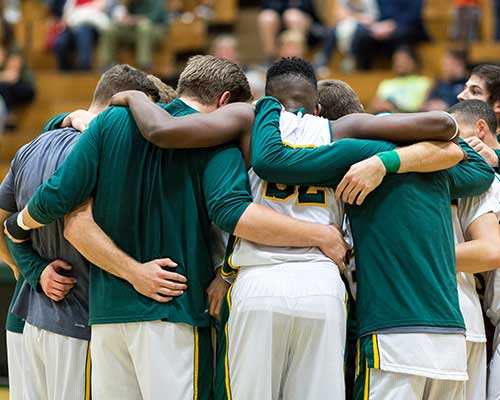 mens basketball team embracing