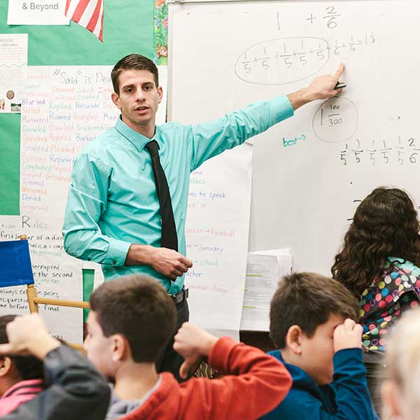 Male teacher pointing to the white board