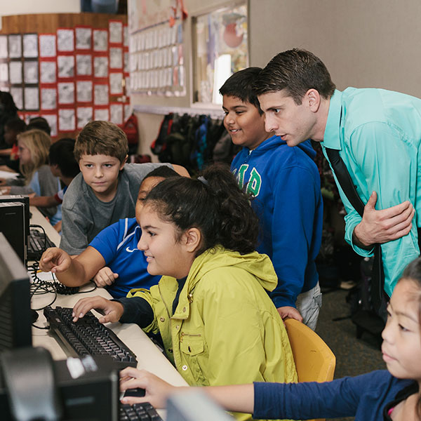 Teacher working with students on a computer