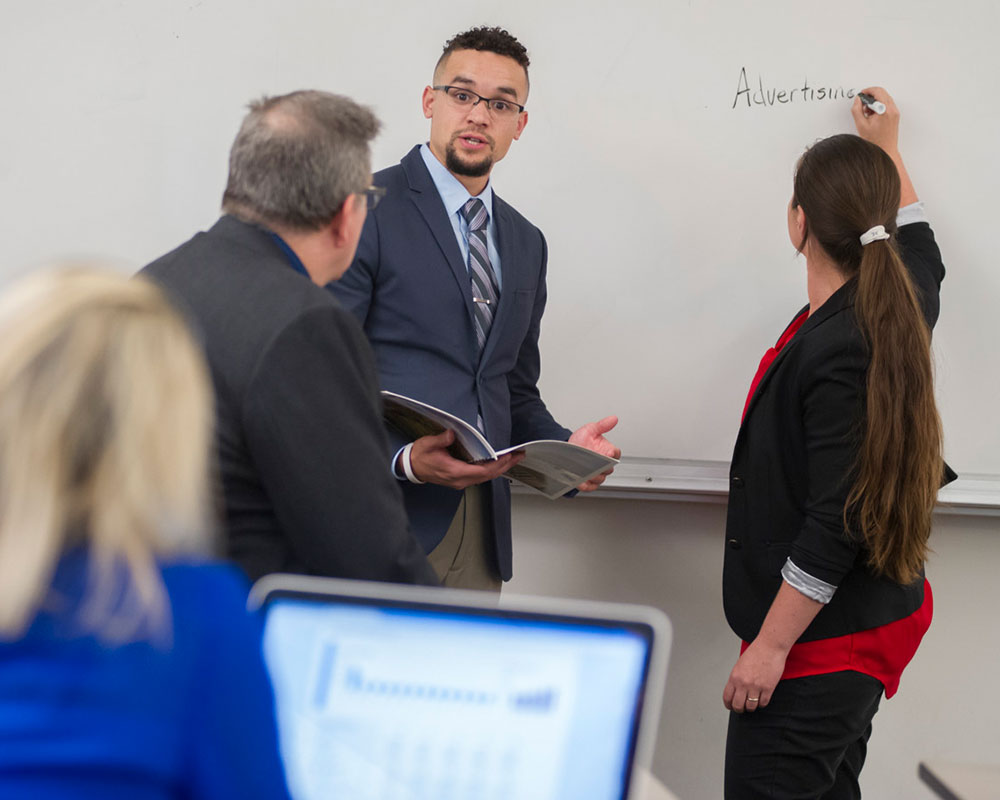 Students writing on the white board in class