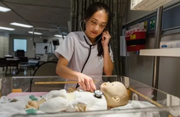 Nursing student with practice baby dummy