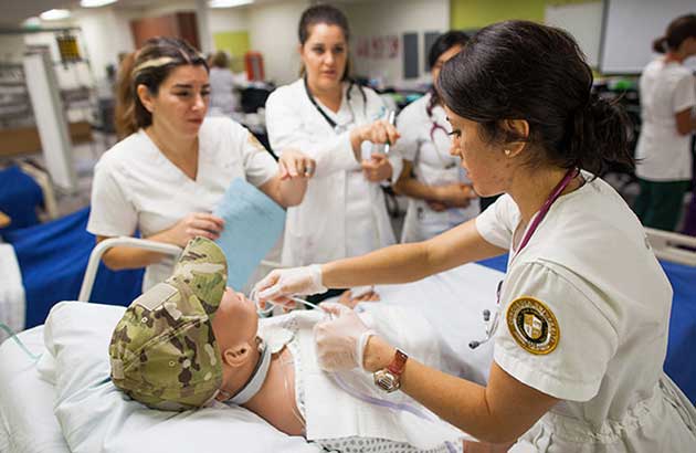 Nurses practicing on a full sized test dummy.