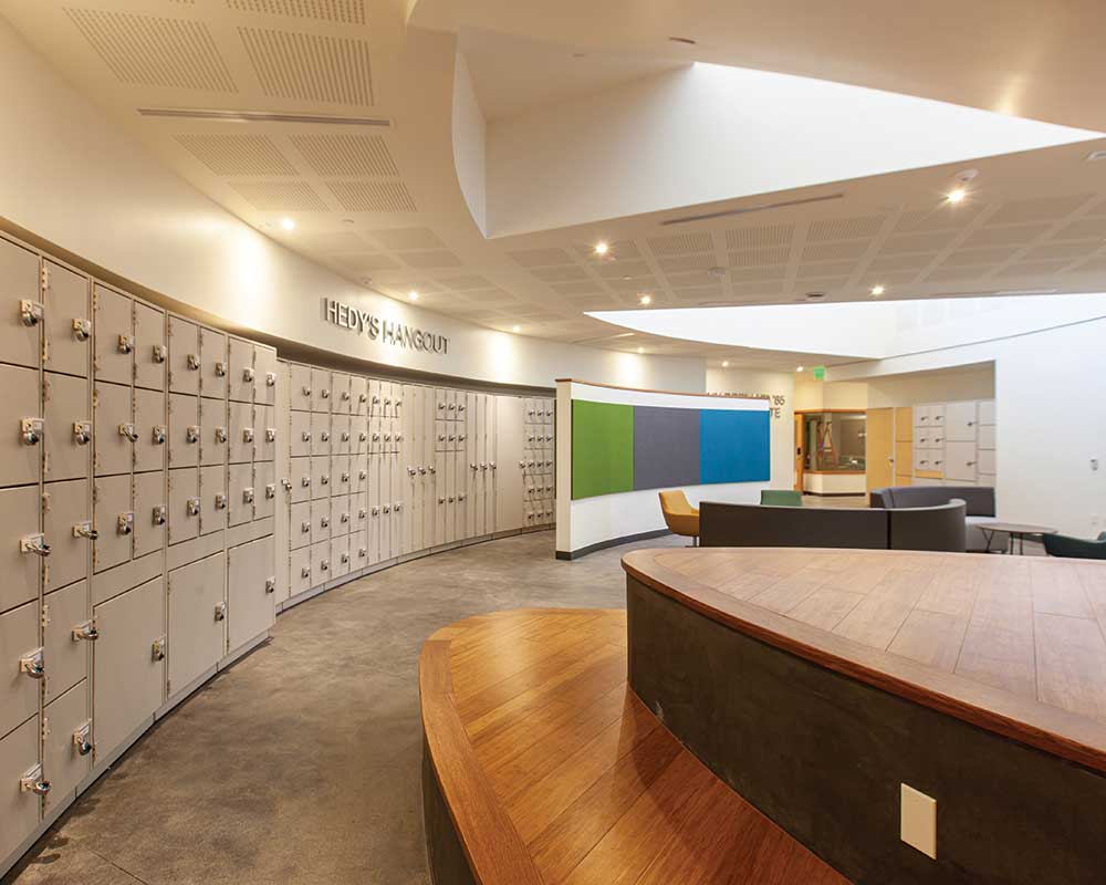 Instrument lockers flank the open student lounge in Hedy’s Hangout, which has easy access to the Caryn Borland ’85 Recording Suite., the bottom floor music lesson and practice room hallway, the music classroom, the music library, and the music office.