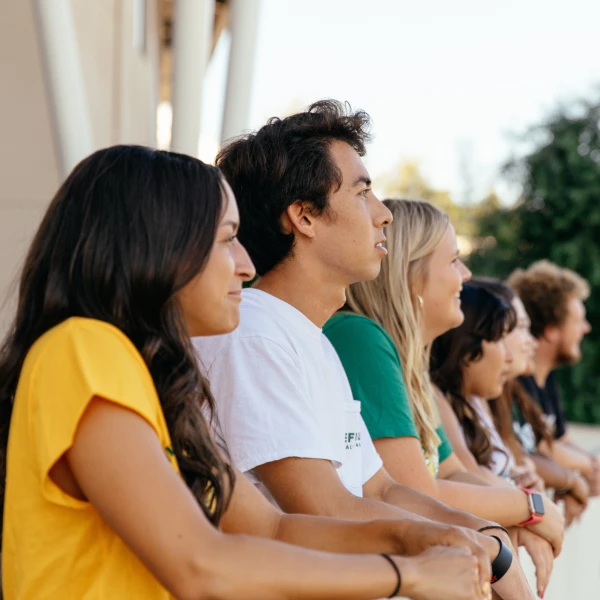 Group of students sitting outdoors, looking ahead