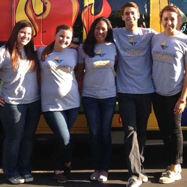 Group of five students standing in front of a van