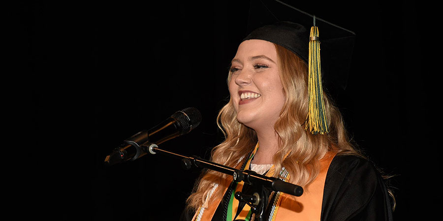 Laura Pierson speaking on stage at graduation