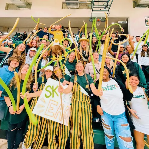 Students posing for a photo at a basketball game