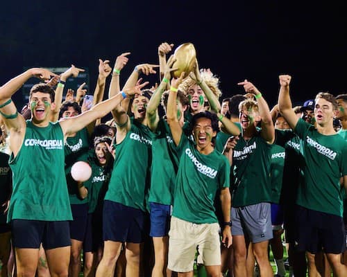 A group of people cheering and holding up the Golden Egg