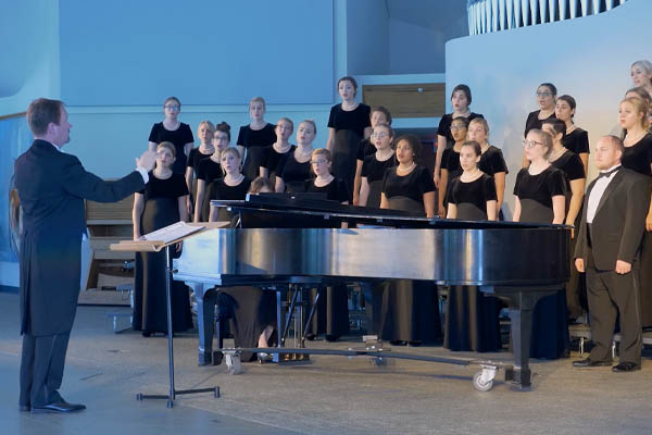 Conductor leading choir members at an event