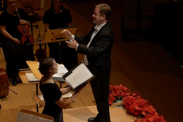 Conductor leading the orchestra and vocal soloist