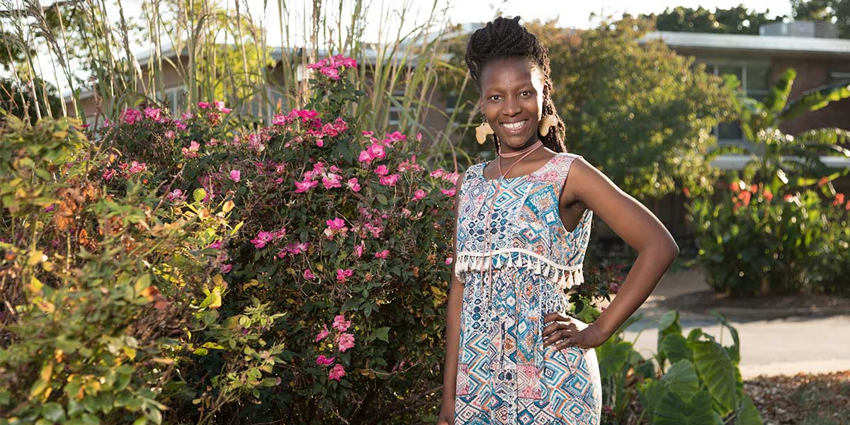 Noks Shabalala standing in front of flowers.