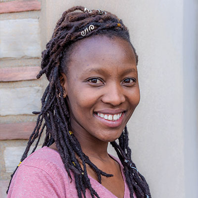 Noks Shabalala standing in front of flowers.