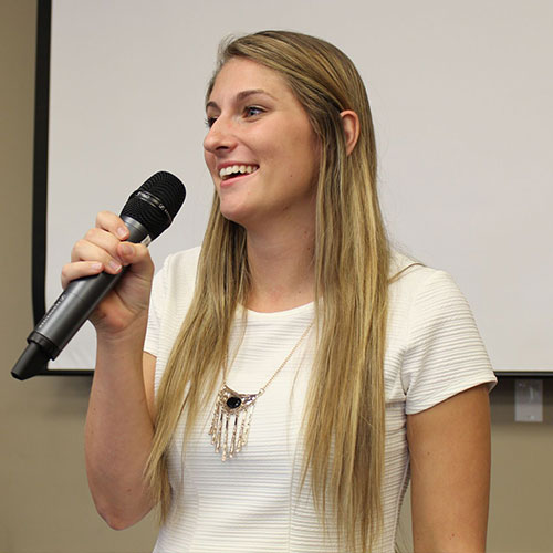Taylor Kelso speaking into a microphone