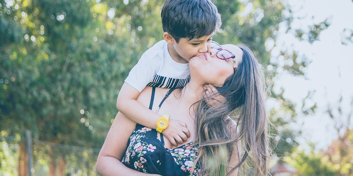 Young boy kisses mother