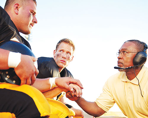 Football coach speaking with a player