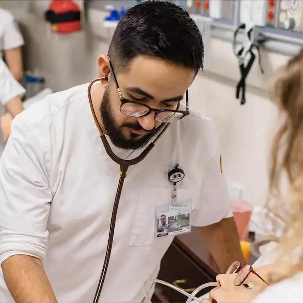 A male nurse examining a mannequin