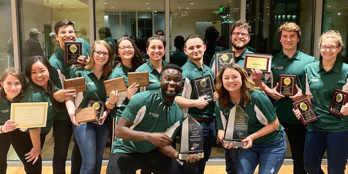 Members of the CUI Debate team hold plaques and award trophies they won at the National Parliamentary Debate Association Championship Tournament in March 2019.
