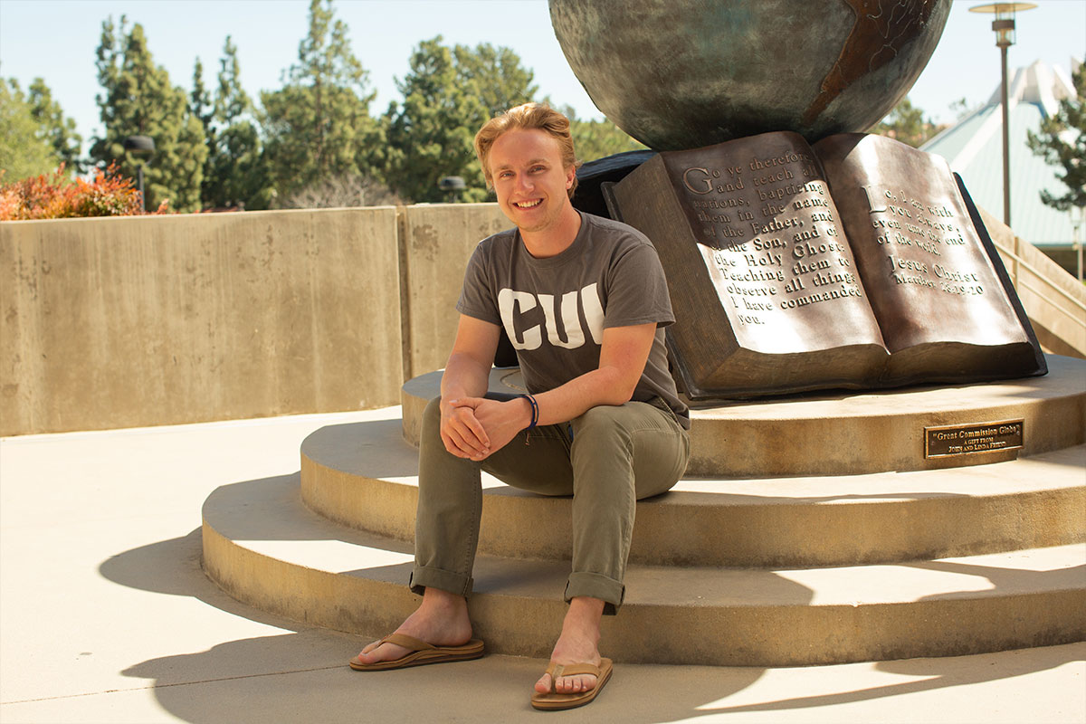 Nathan MacGregor sitting by the globe