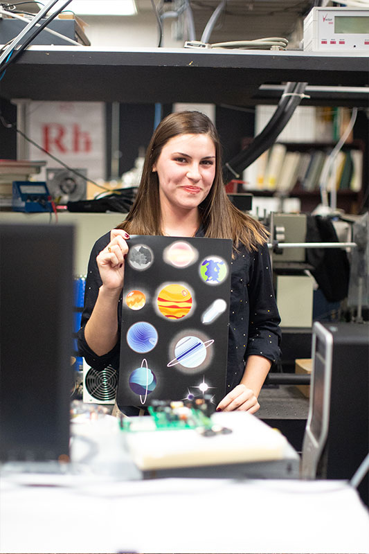 Susan Eschelbach holding one of her pieces in the science lab