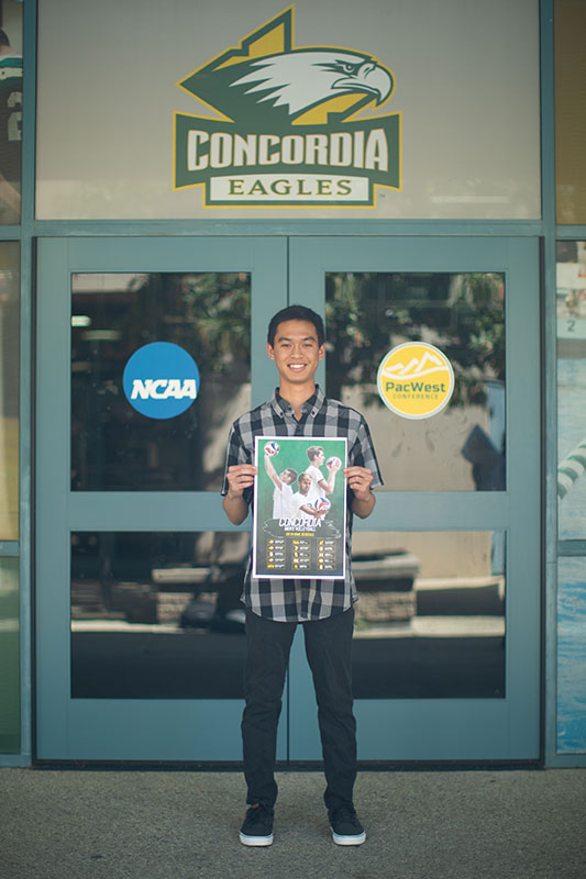 Troy Makalena holding a poster that he designed