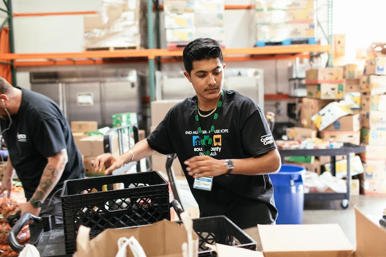 male student working at a food pantry as a part of college corps