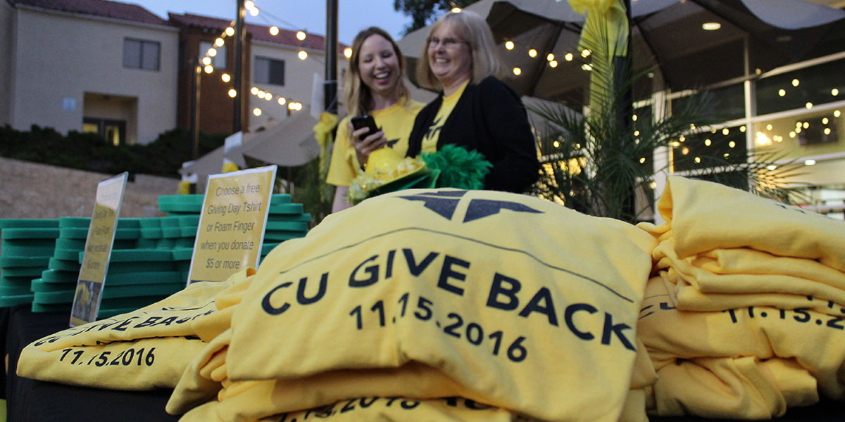 Volunteers help with a Give Back T-shirt table