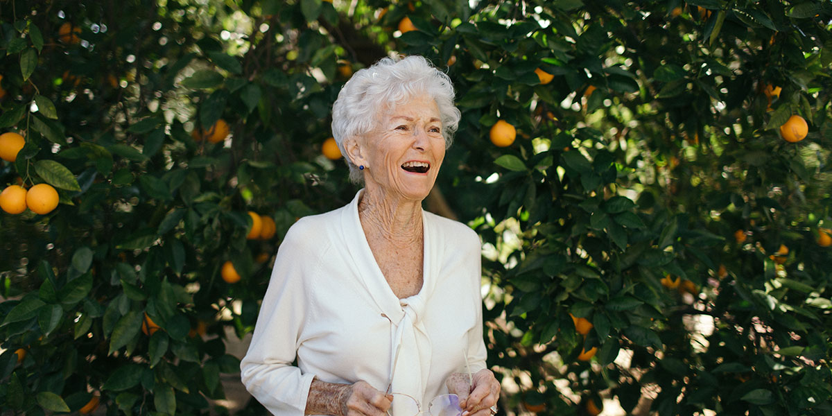 Elayne Lohr in front of multiple orange trees