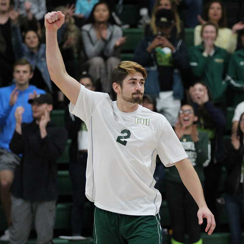 CUI men's volleyball players bowing their heads for prayer before a game