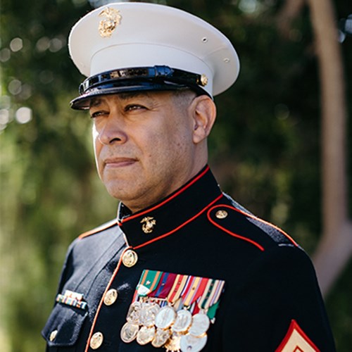 Shining metals fill John Gallegos chest on his Marine Corps Uniform.