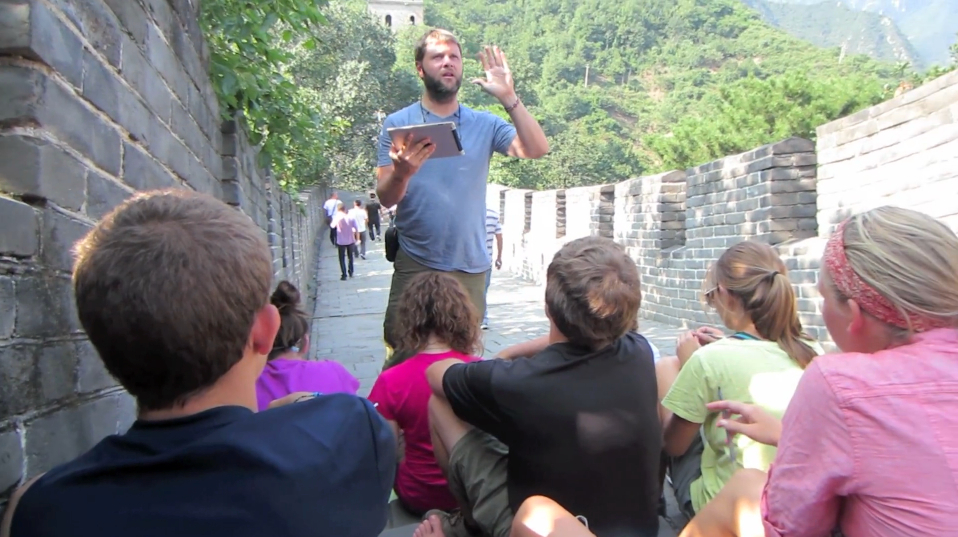Man teaching to students on the Great Wall of China