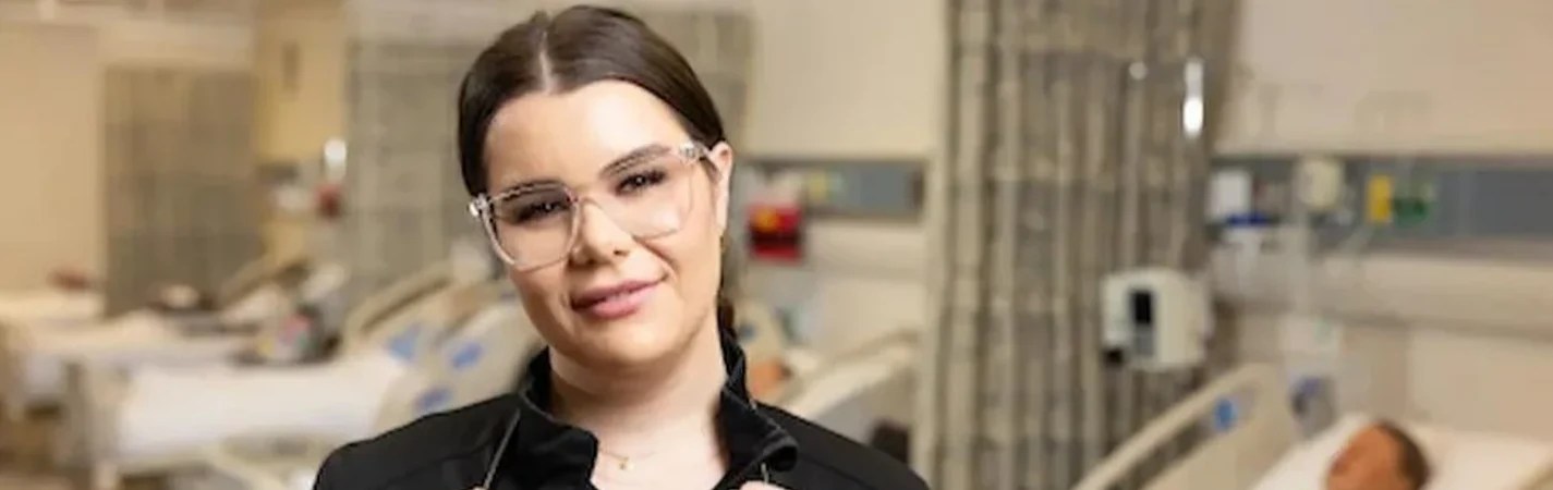 A woman wearing glasses and smiling