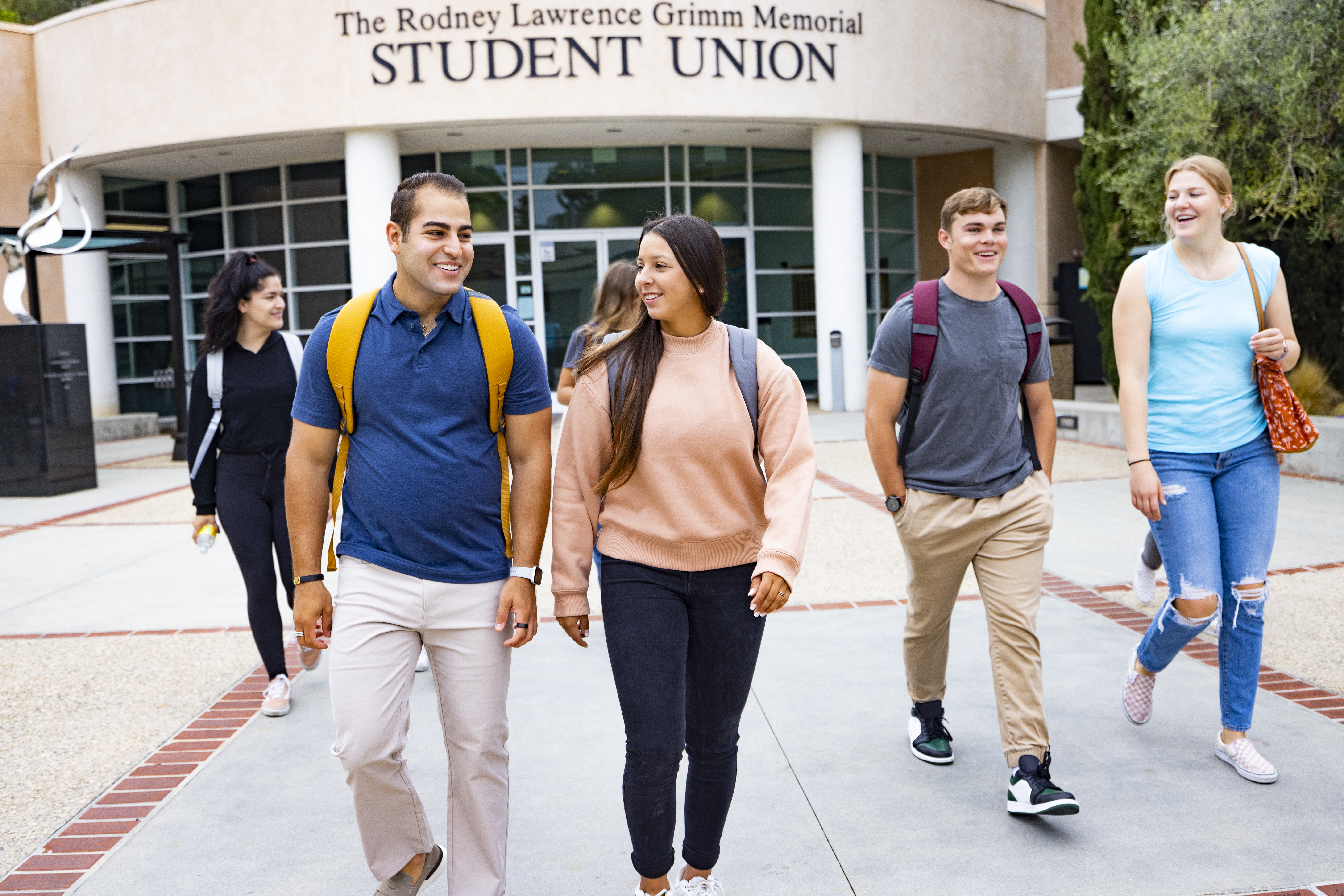 A group of people walking outside of a building
