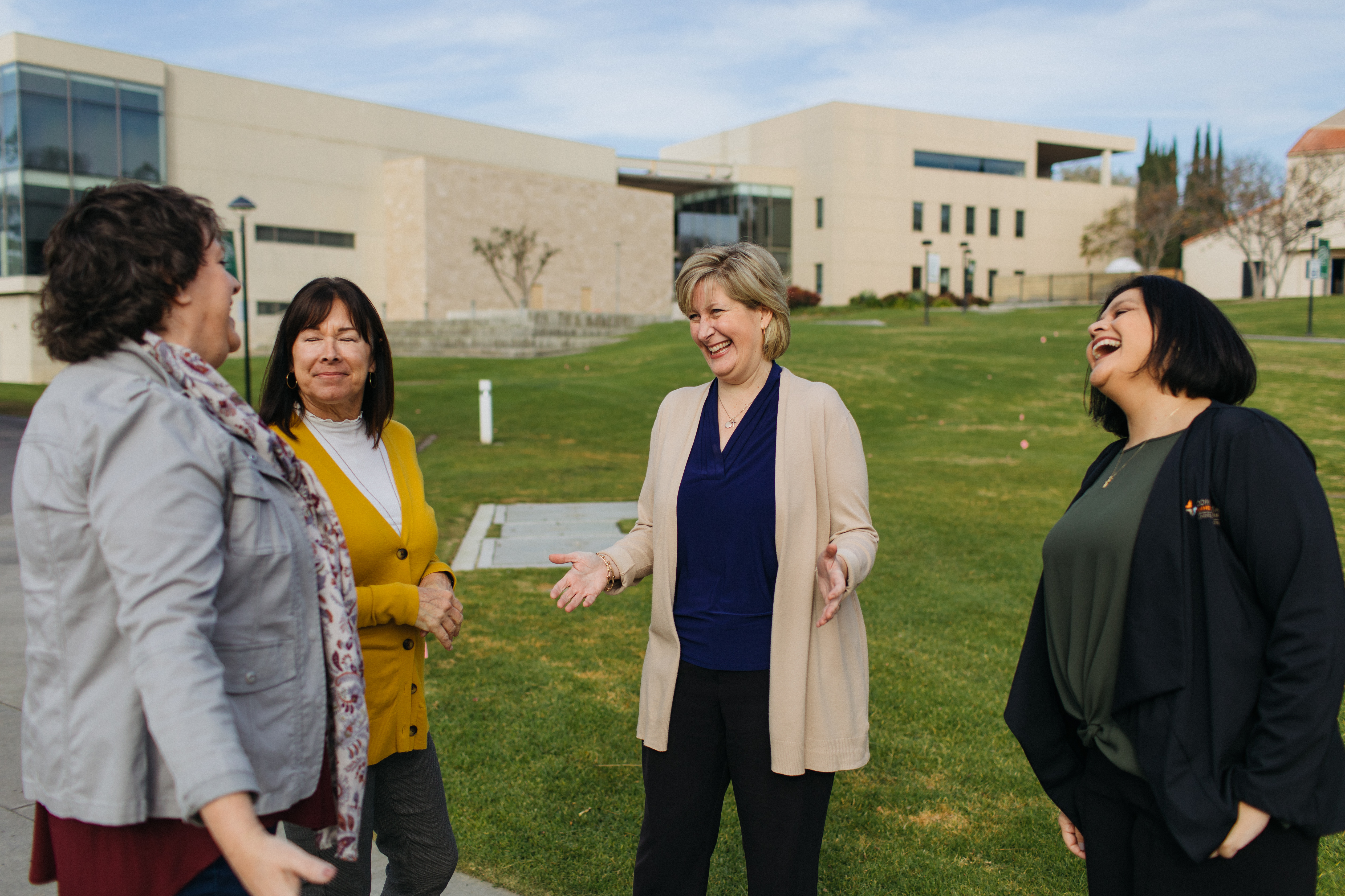 A group of women standing in a grassy area
