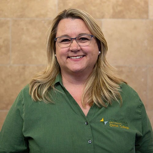 A woman wearing glasses and a green shirt