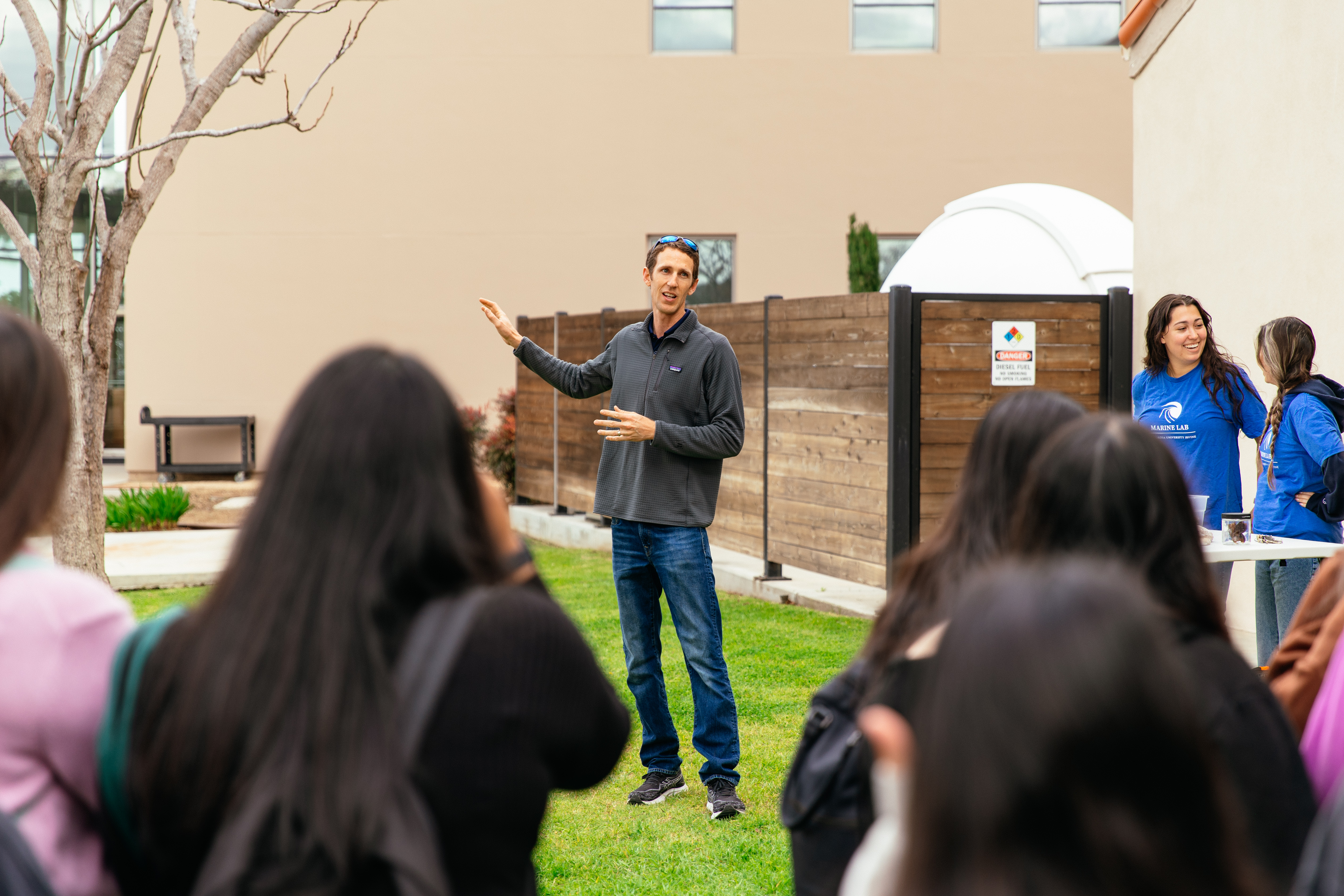 A man standing in a grassy area with a group of people