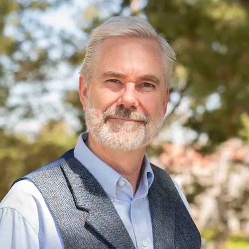 A man with a beard and mustache wearing a vest