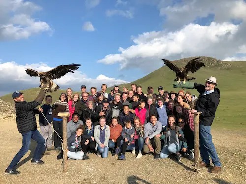 A group of people posing for a photo with eagles