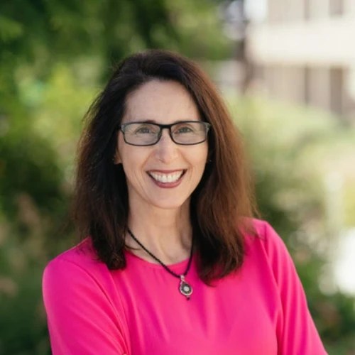 A woman wearing glasses and a pink shirt